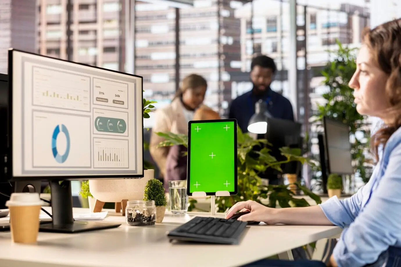 В корпорации профессиональный сотрудник работает за рабочим столом с зелёным экраном.